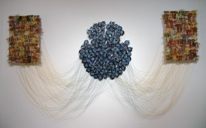 "The Stream of Consciousness" 2008, linen threads, dyed and covered with wax, stitched on the fabric on one side, and tied with rusted razor blades on the other. Three hundred razor blades are connected to the disc magnets suspended away from the wall, 4’ H x 10’W x 1’ D